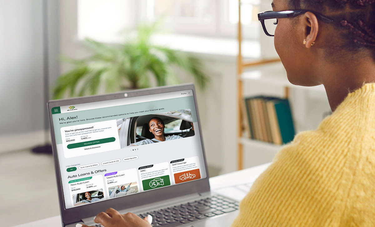 A woman uses a laptop to browse personalized financial offers made possible through the adaptable Digital Storefront.