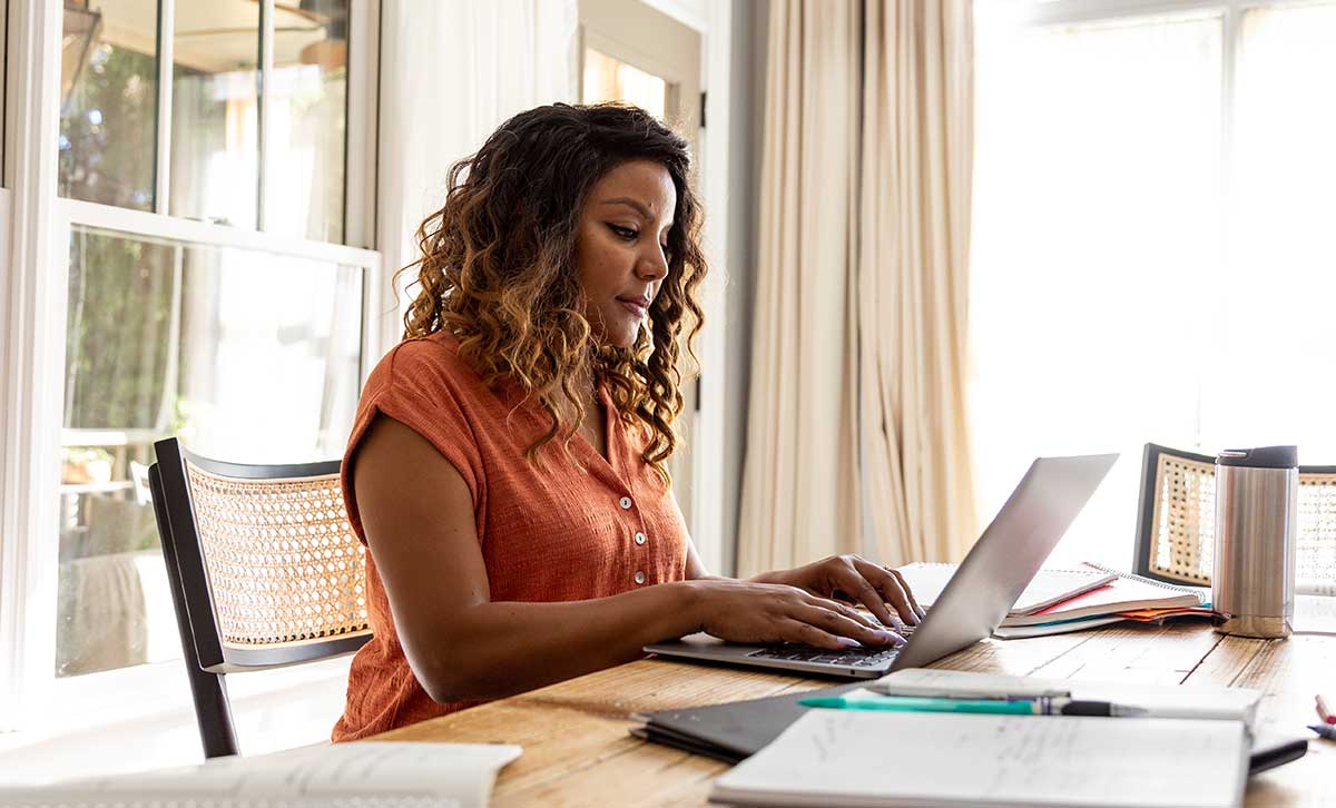 Woman sitting at her laptop reading about TruStage Investment Management