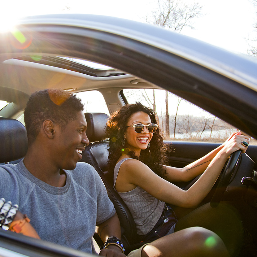 Two people discussing the benefits of TruStage Payment Guard while driving.