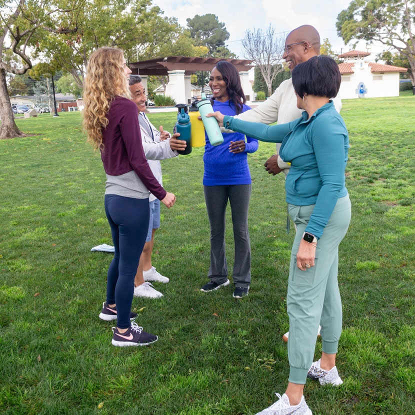A group of people stand around talking about TruStage