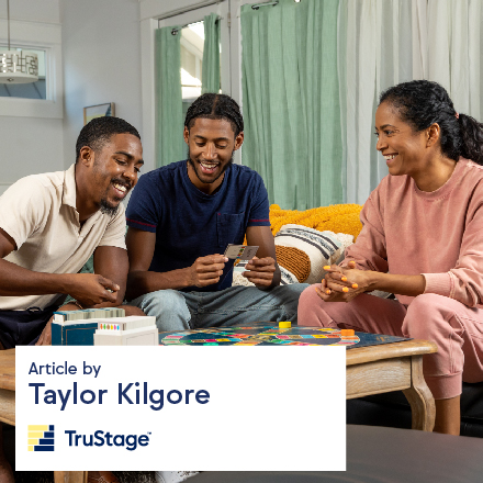 A Black family playing a game at a table and having fun