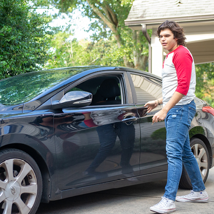 Young man opening his car door