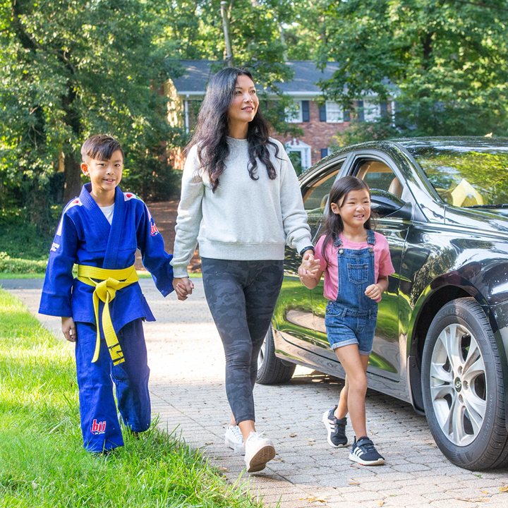 A family arriving home and holding hands