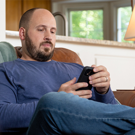 Man learning about life insurance scams on his phone