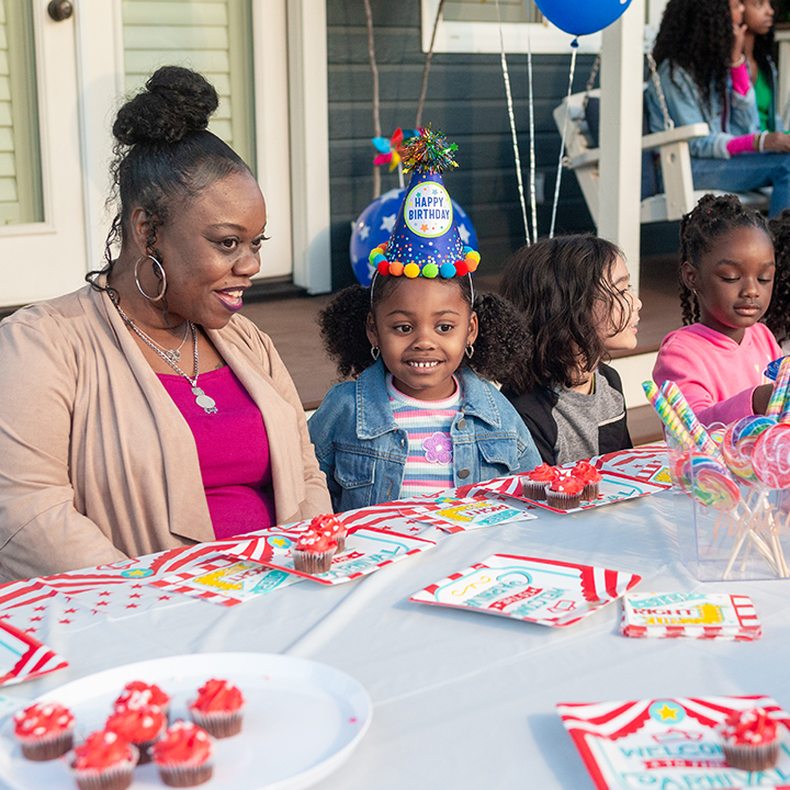 A mother and daughter smiling at a birthday party