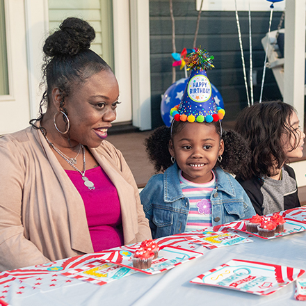 A mother and daughter smiling at a birthday party