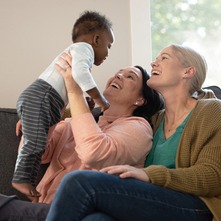 Two new parents playing with their baby, thankful for their life insurance policy