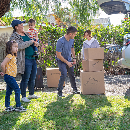 A family unloading boxes from their vehicle