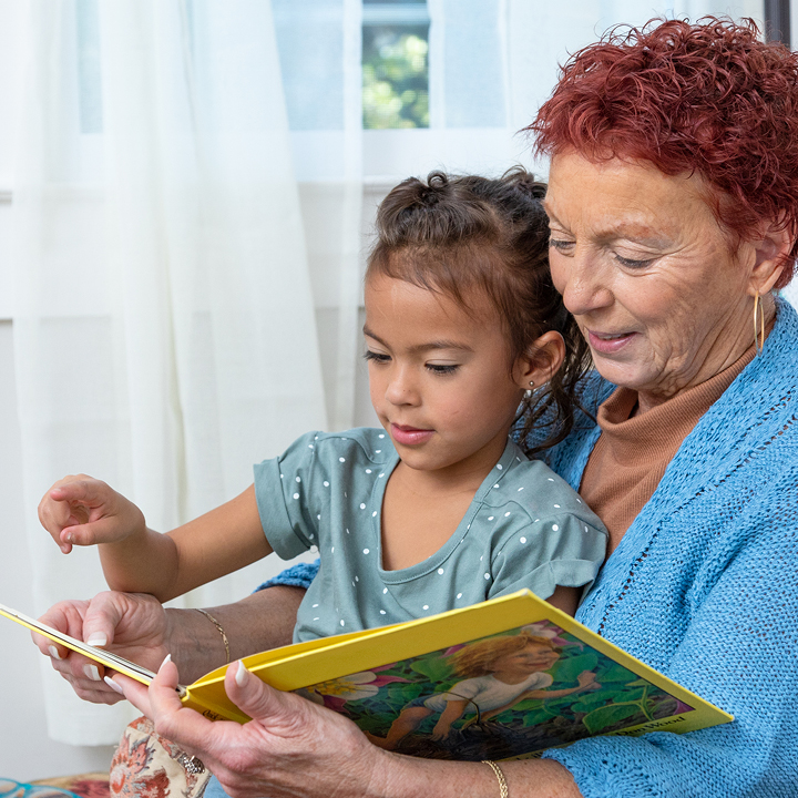 A grandmother and granddaughter reading a book together