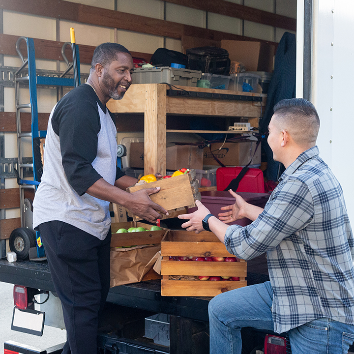 Two veterans removing boxes from a truck