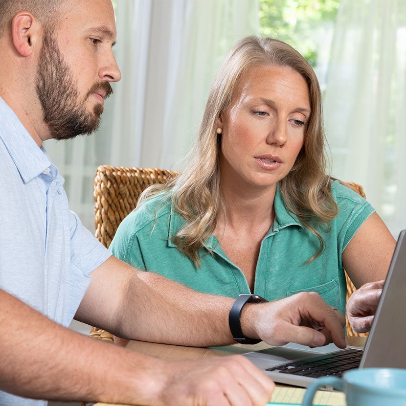 A couple learns about TruStage payment protection while applying for their loan online. 