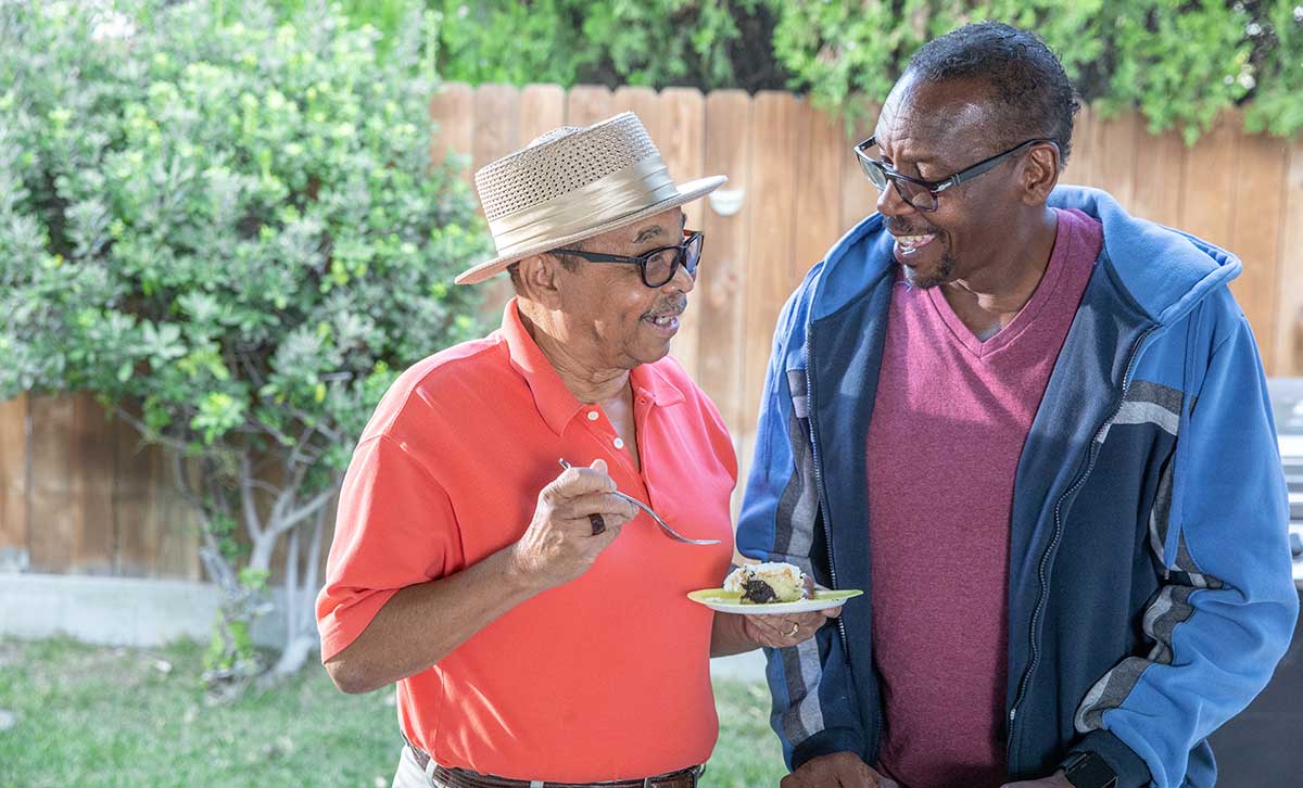 Two friends discuss the benefits of TruStage™ annuities as part of their retirement portfolio while eating cake.