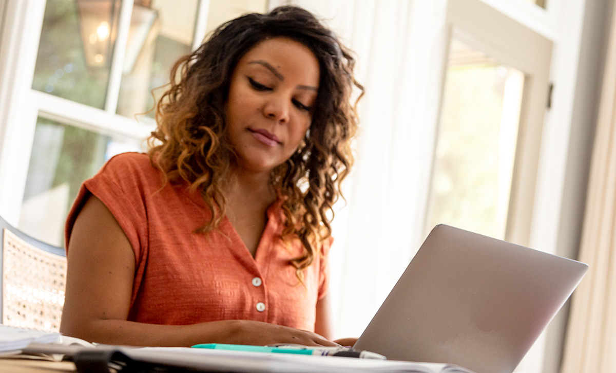 Woman with laptop checks her MEMBERS® Future Income Annuity - it uses the power of deferral to help maximize  guaranteed future income. 