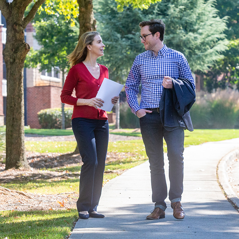 A woman and man walking outside discuss  what they learned from TruStage™ about guaranteed lifetime withdrawal benefits.