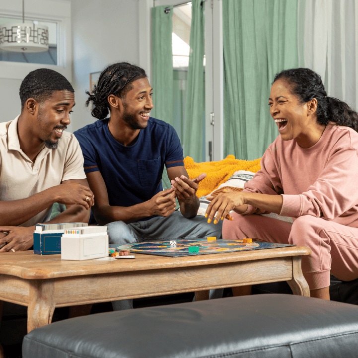 Family discussing the importance of life insurance and accidental death and dismemberment insurance while playing a board game.